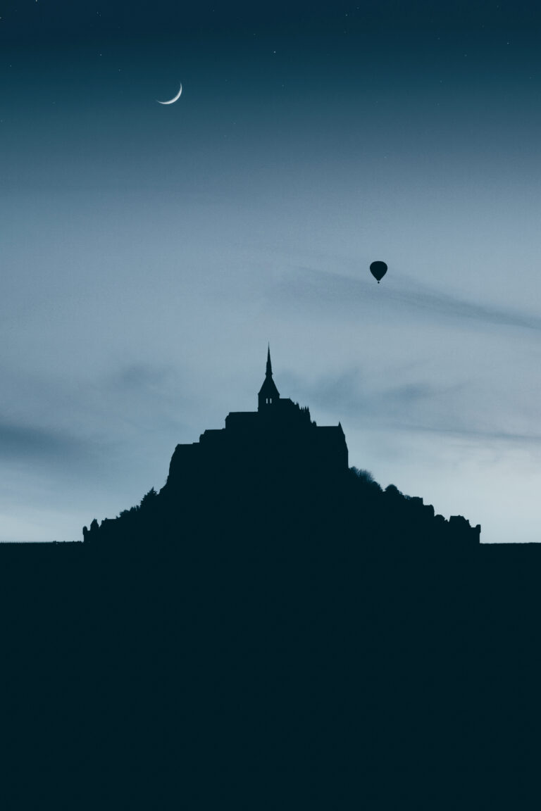Photographie du Mont-Saint-Michel éclairé par la lumière du matin. Image emblématique du patrimoine architectural français.